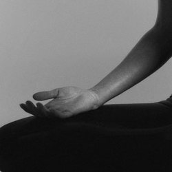 Une main posée sur le genou, en position assise